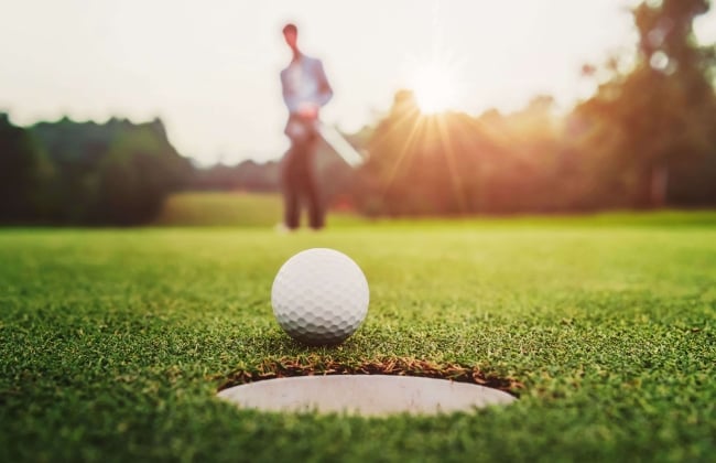 image of a golf ball on the edge of the cup
