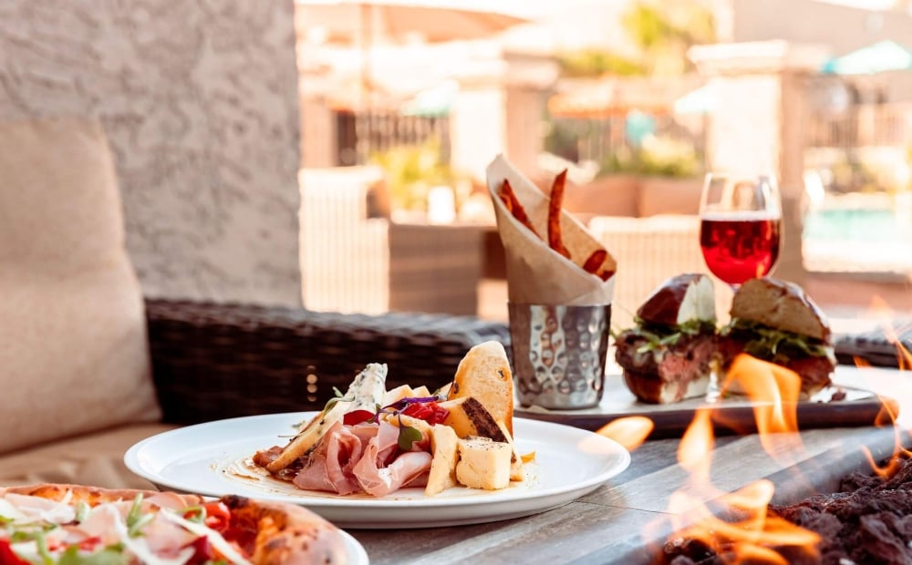 Image of plated food sitting next to an outdoor fire pit